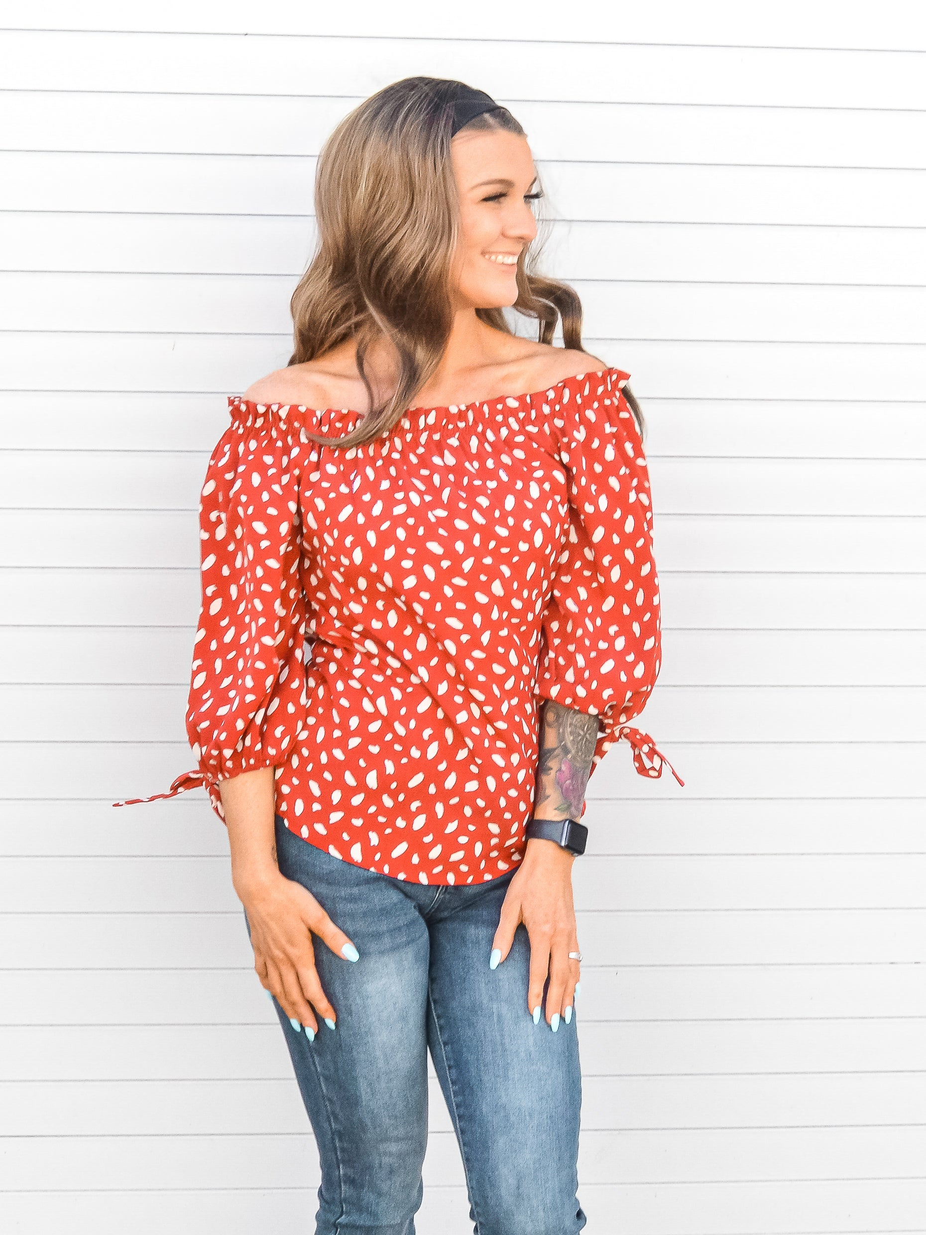 Red off the shoulder blouse with 3/4 sleeves and animal print patterned.