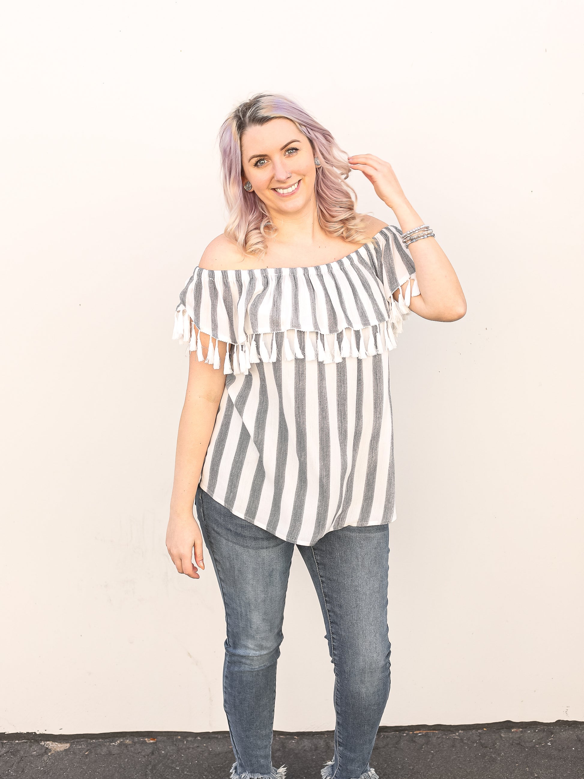 White and grey vertical stripe off the shoulder top with tassels. 