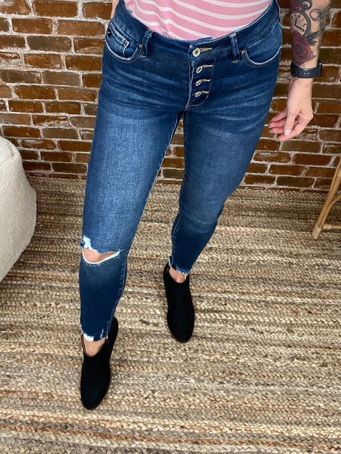 Dark blue jeans with button fly and knee cut out. 